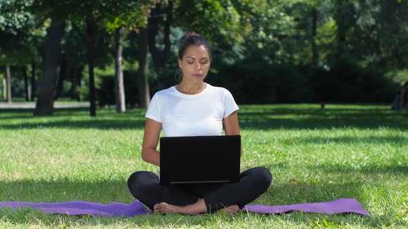 Girl Yoga in the Park Working on a Laptop