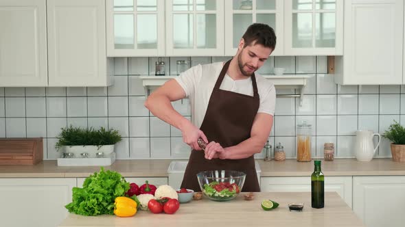 Male Chef Adding Spices to Vegan Salad While Standing in Kitchen at Home