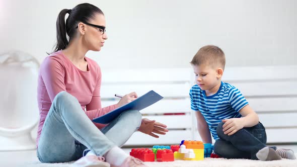 Casual Young Woman Child Psychologist Talking with Little Cute Boy During Psychotherapy