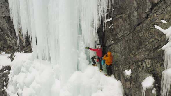 Two climbers break ice to prepare scaling cascade Maineline, Kineo