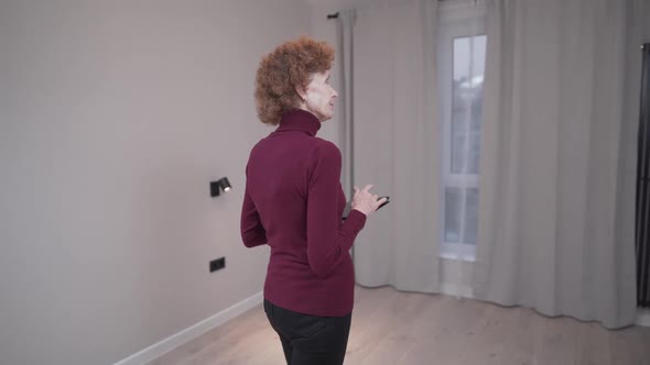 Caucasian Mature Woman Inspecting an Empty Apartment Before Signing a Lease Agreement