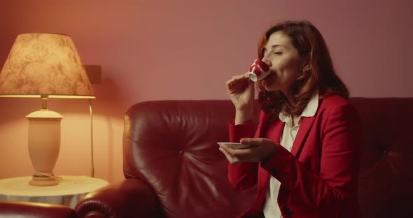 Girl is enjoying coffee while sitting in the sofa at home