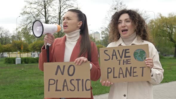 Two Women are Standing with Posters SAVE THE PLANET and NO PLASTIC