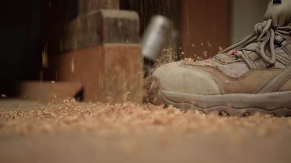 Sawdust Falling To the Ground Next To Work Boots in Slow Motion