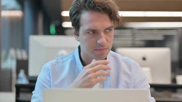 Close Up of Man Thinking While Using Laptop
