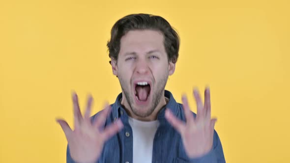 Irritated Young Man Shouting Screaming on Yellow Background