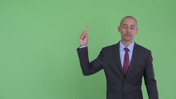 Stressed Bald Multi Ethnic Businessman Pointing Up