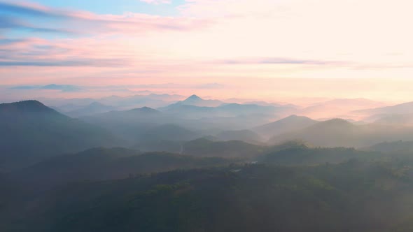 4K aerial view from a drone flying over the valley, fog in the morning.