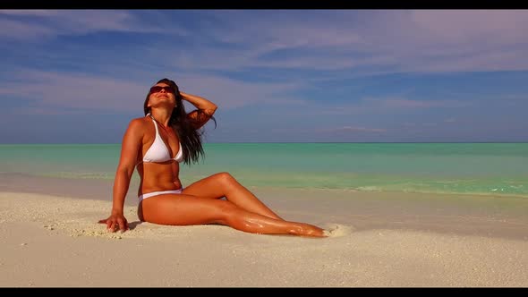 Lady suntans on idyllic coast beach adventure by transparent ocean with white sand background of the