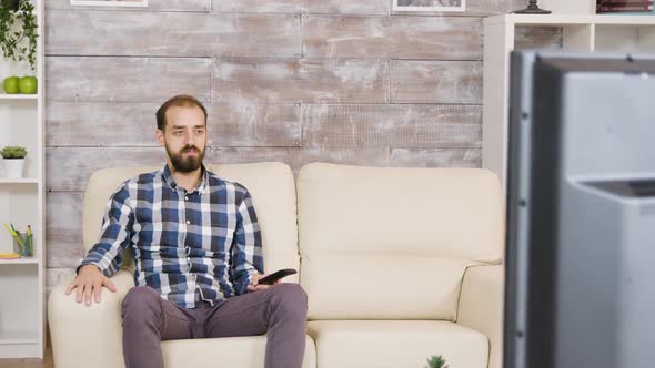 Bearded Man Sitting with Serious Face Watching Tv