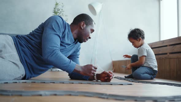 Top View of Boy and Father Playing with His Train