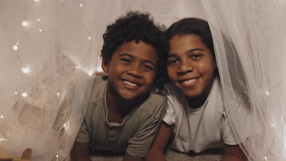 Girl and Boy Posing in Blanket Fort