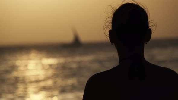 Silhouette of a Beautiful Young Woman Looking at the Sunset in the Ocean Africa