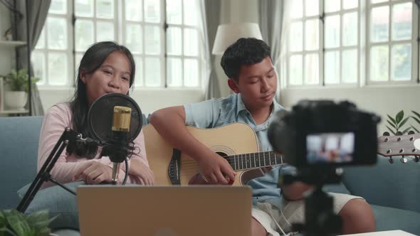 Asian Boy Playing Guitar And Girl Sing A Song While Live Streaming