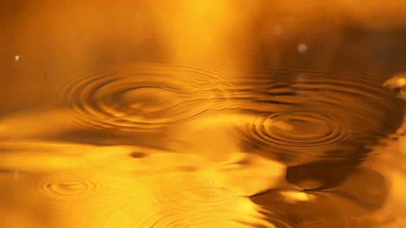 Super Slow Motion Detail Shot of Water Drop on Golden Luxury Background at 1000 Fps