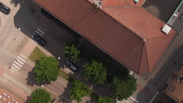 Swedish town building rooftops with city street traffic, aerial top down fast flying view