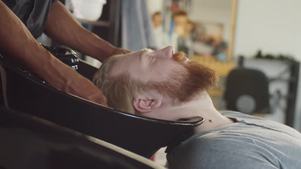 Man Getting Hair Wash in Barbershop