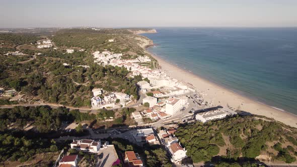 Charming old fishing village of Salema, Algarve. Long sand beach and emerald ocean. Aerial