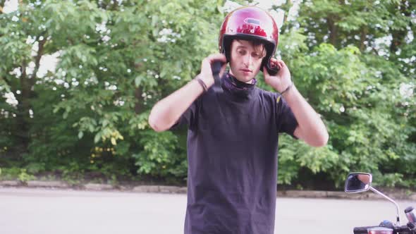 The Young Biker Wearing a Helmet for Riding a Motorcycle. Close Up