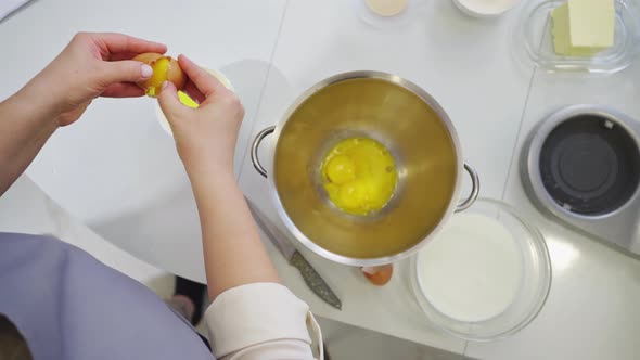 A Woman Breaks an Egg and Separates Yolks From Proteins