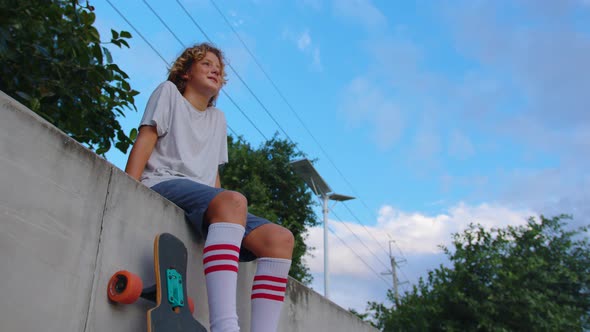 Happy Teenager Stylish Skater Boy Holding His Skateboard Outdoors