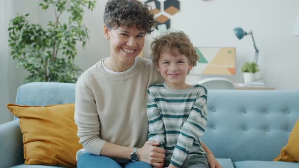 Portrait of Happy Young Family Mother and Son Smiling Indoors at Home