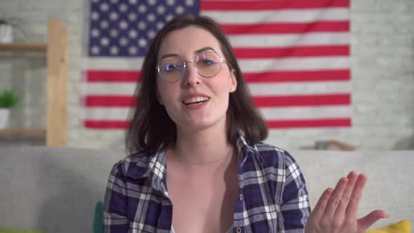 Young Woman Blogger in Shirt on American Flag Background Recording Video Close Up