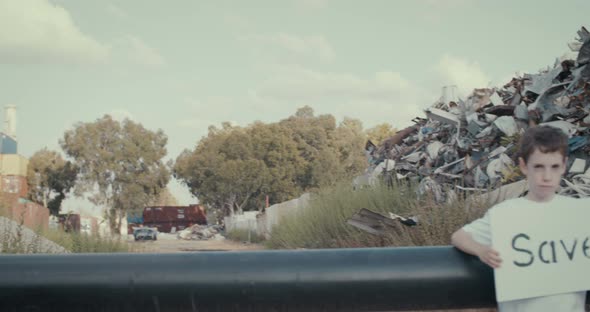 Save the planet. kids holding signs standing in a huge junkyard