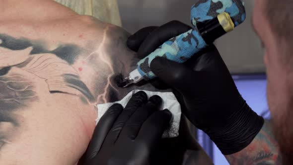 Cropped Shot of a Professional Tattooist Working at His Studio