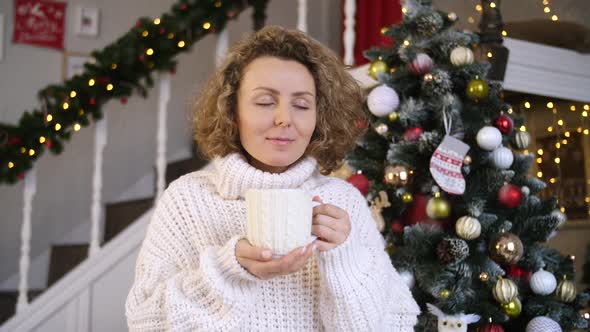Christmas, Holidays And People Concept - Happy Young Woman With Cup of Hot Chocolate At Home