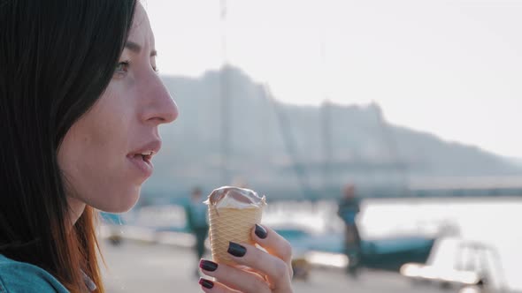 Happy Woman Eating Ice Cream on Vacation Travel. Close Up Smiling Girl Having Fun Eating Ice Cream