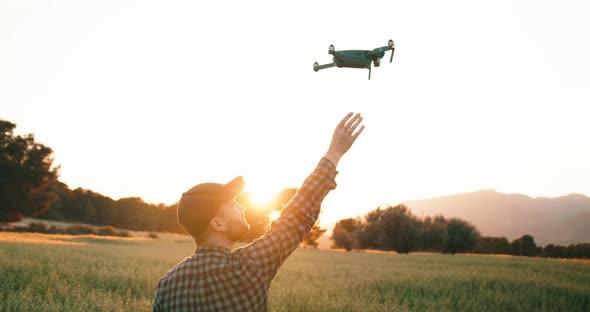 Drone Flies From Hands Of Man At Sunset in Nature.Close up tracking shot.