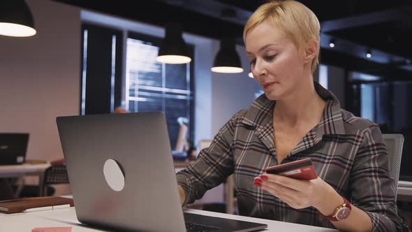 Woman Using Personal Computer and Plastic Card To Making Online