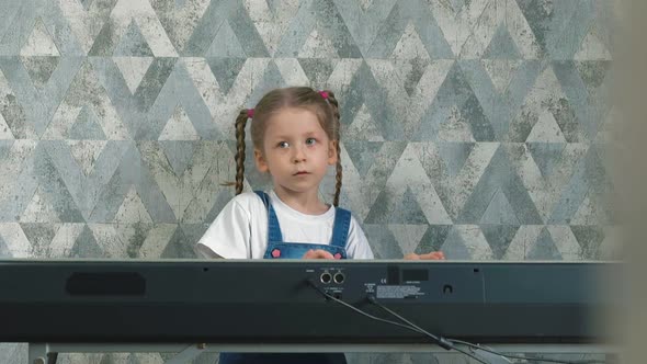 Girl with Long Pigtails Plays on Electronic Piano