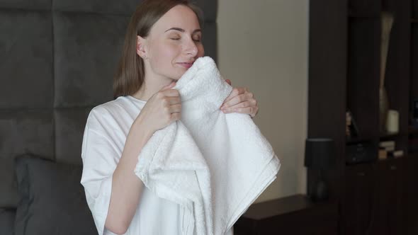 Young Woman Sniffing Fresh Towel in Living Room