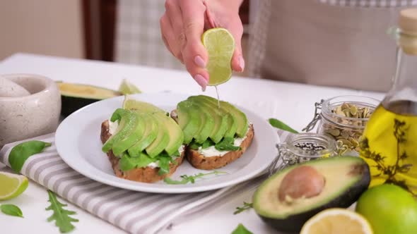 Woman Prepares a Healthy Breakfast or Snack  Soft Cheese Sandwich with Avocado