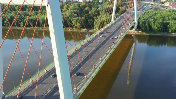 Aerial view of the Bridge. Cloudy fog soaring above the traffic on the red bridge over the green wat