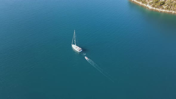 Aerial drone tracking video of luxury yacht cruising in blue open sea