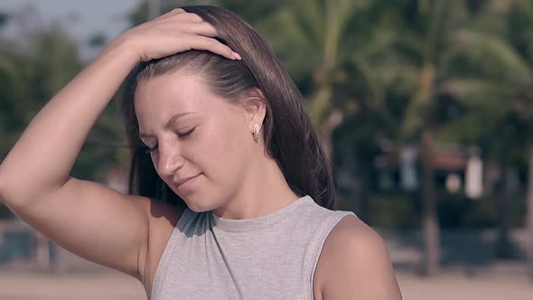 Attractive Lady Fixes Hair By Hand Against Palm Slow Motion