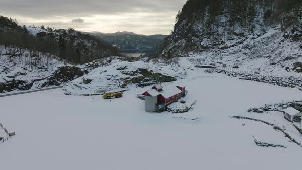 Red and white houses in snow covered valley. Refuge in snowy landscape. Sunset