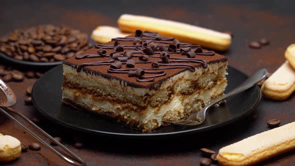 Portion of Traditional Italian Tiramisu dessert, savoiardi cookies and coffee beans