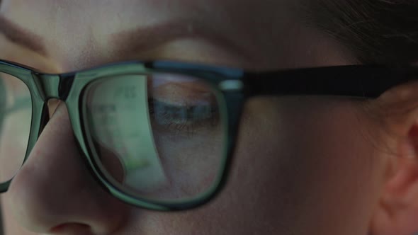 Woman in Glasses Looking on the Monitor and and Working with Charts and Analytics