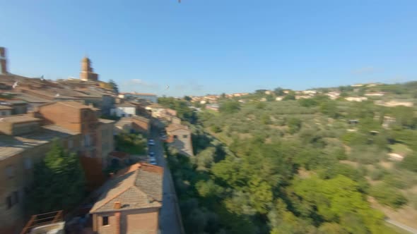 Flock of birds over a medieval village in the Tuscan hills. Sinalunga, Italiy. Aerial view