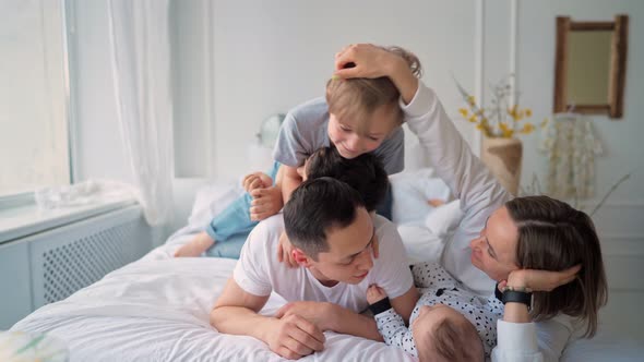 Family with Three Kids Having Fun in Bed