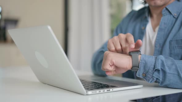 Close Up of Male Hand with Laptop Using Smart Watch