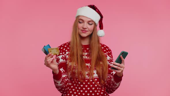 Woman in Christmas Sweater Use Mobile Cell Phone and Plastic Credit Bank Card Win Calebrate Wow