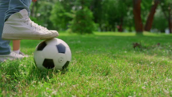 Unknown Human Legs Kicking Ball on Grass Closeup