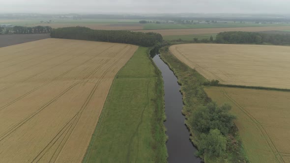 Aerial shot flying above the River Forth and farmland in the Stirlingshire countryside on a overcast