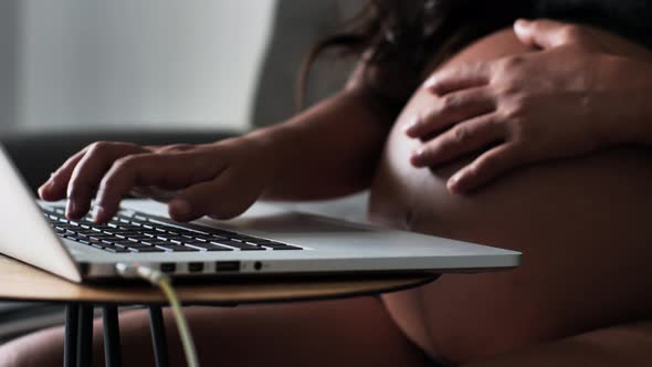 Macro Shot on a Working Pregnant Woman Caressing Her Big Round Belly