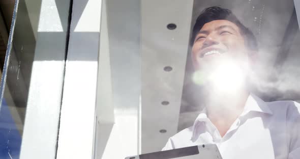 A smiling man using a tablet computer